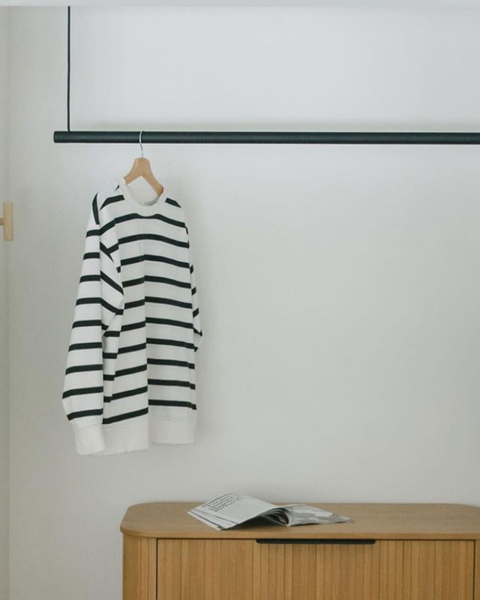 Black hanging clothing rack in a bedroom